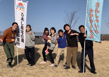 看板の前に立つスタッフ